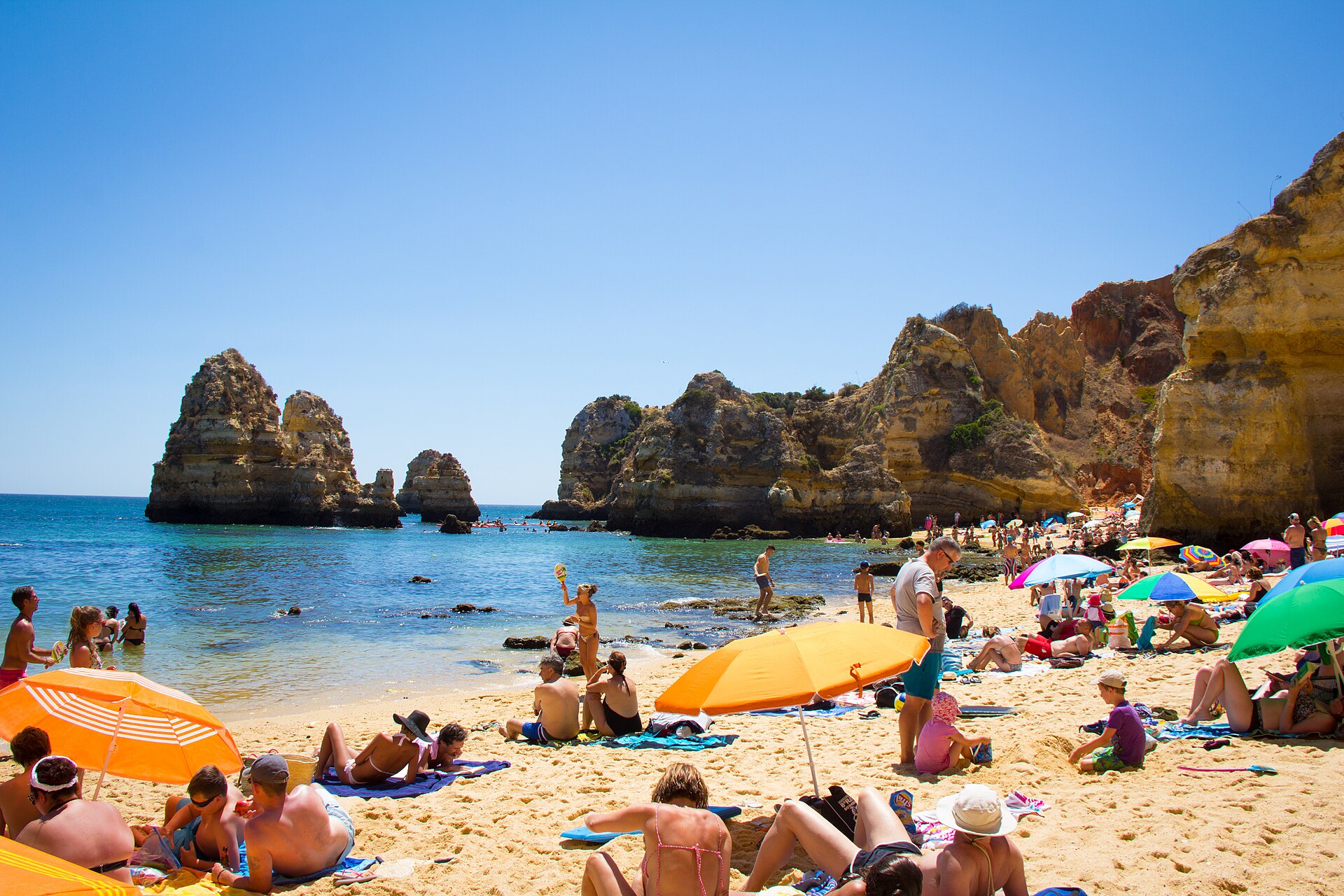 Praia do Camilo, em Lagos, com rochas junto ao mar e areal dourado